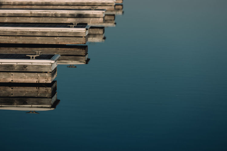 Docks reflecting on calm lake at marina.
