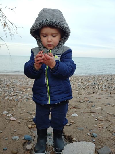 Full length of cute baby boy standing at beach