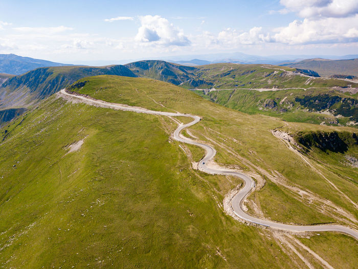 High angle view of winding road on landscape against sky