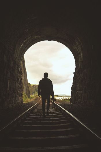 Silhouette of man in tunnel