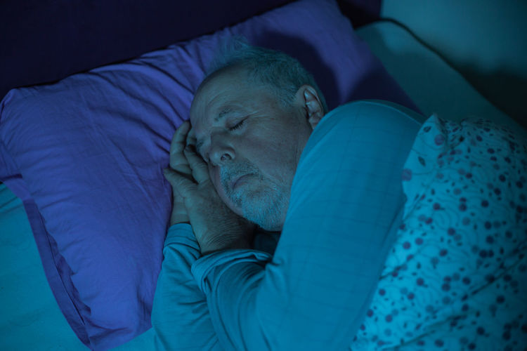 Midsection of man sleeping on bed