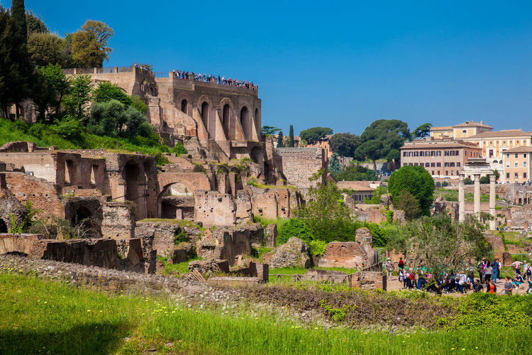 Tourists visiting the domus tiberiana and the roman forum in rome
