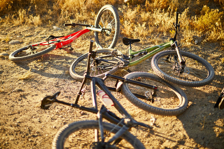 Three mountain bikes in the dirt.