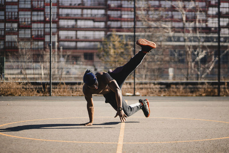 African man doing acrobatic activity on basketball court