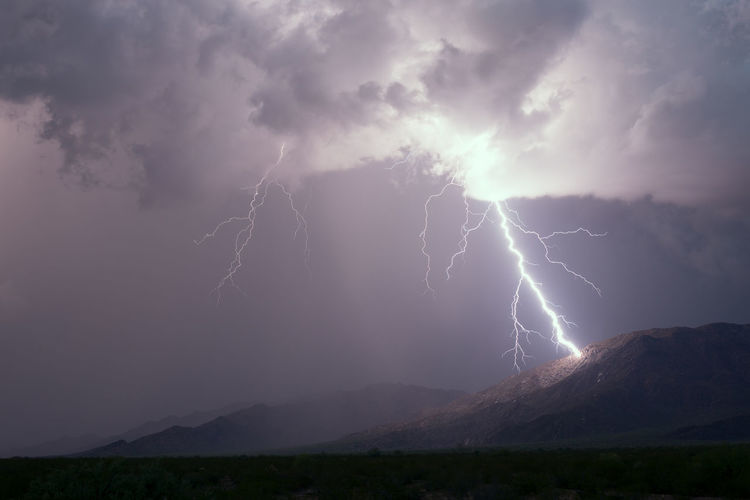 A lightning bolt strikes a mountain during a monsoon thunderstorm in arizona