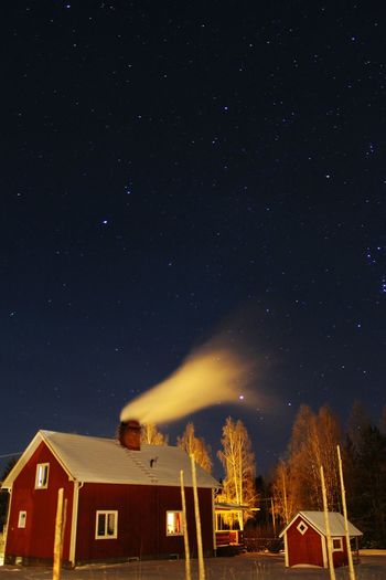 House emitting smoke against star field