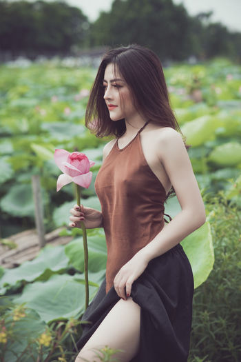 Young woman standing on pink flowering plants