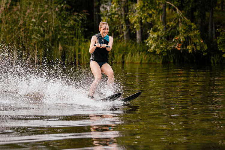 Full length of man splashing water in lake