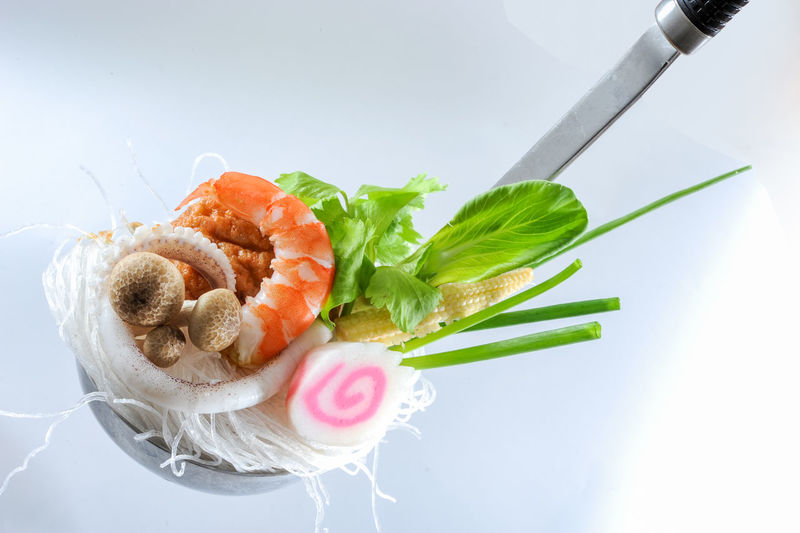 Close-up of seafood in plate against white background