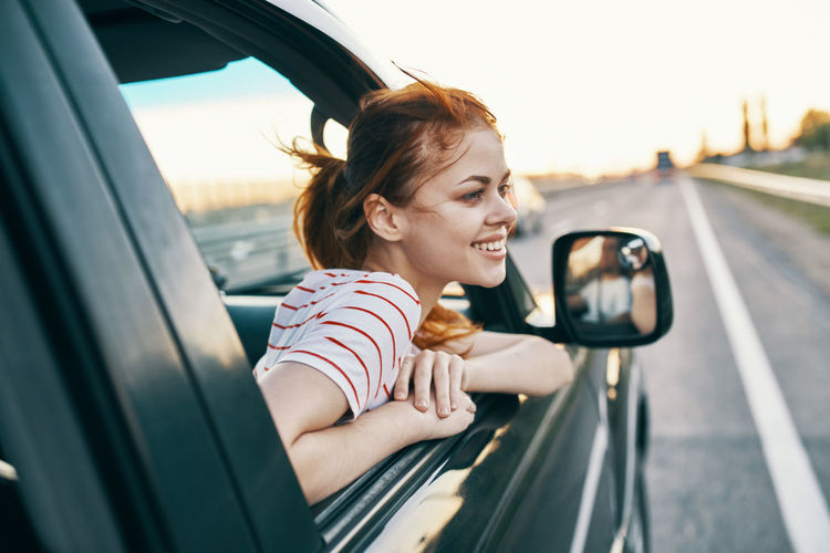 Portrait of happy woman sitting in car