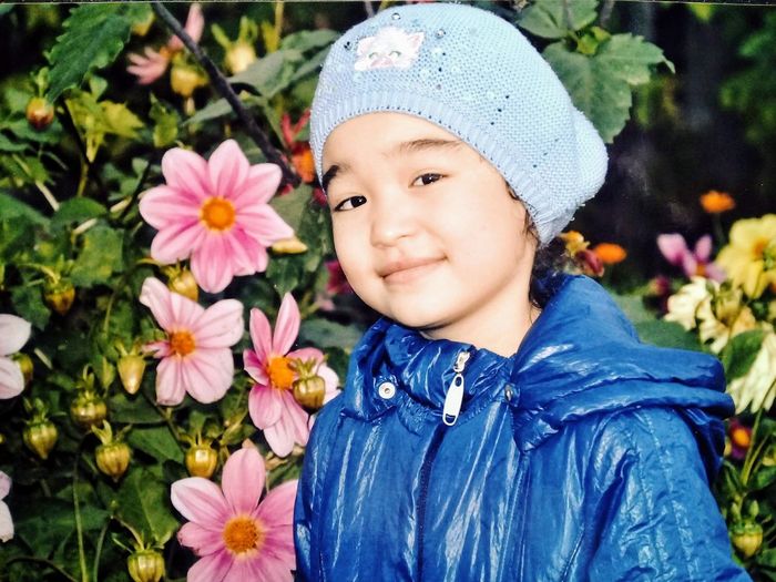 Close-up portrait of cute girl against plants
