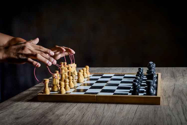 Low angle view of person playing on chess board