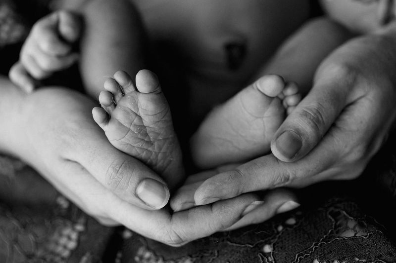 Close-up of cropped mother holding baby feet