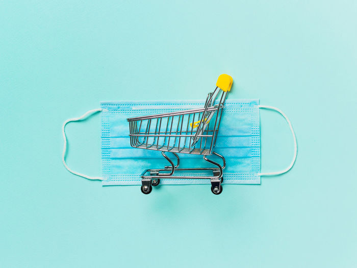 Close-up of shopping cart against blue background