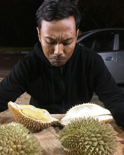 Close-up of man selling durian fruits