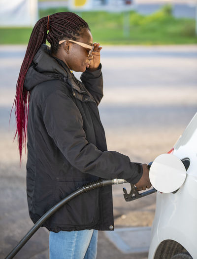 African woman fills the car with diesel at very high prices during the fall