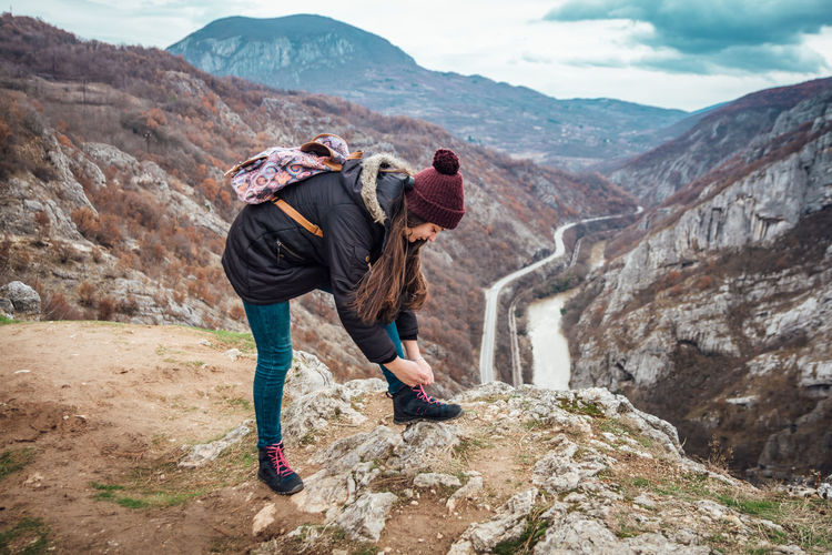 Woman standing on rock against mountains