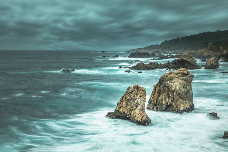 Scenic view of rocks in sea against sky