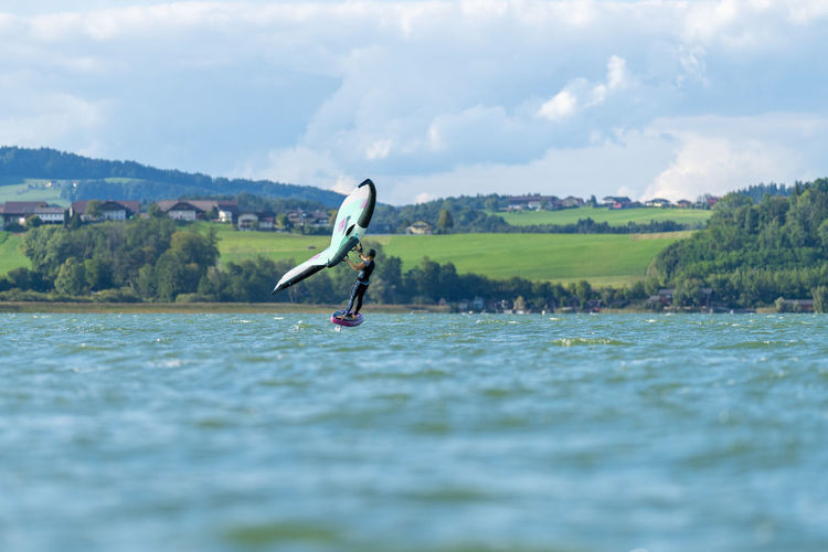 Rear view of man jumping in lake