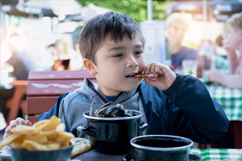 Full length of man eating food at restaurant