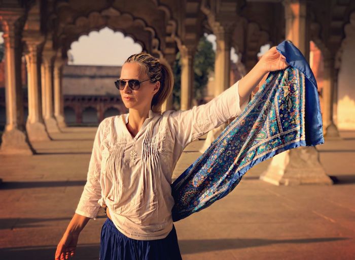 Woman wearing sunglasses with scarf standing in agra fort