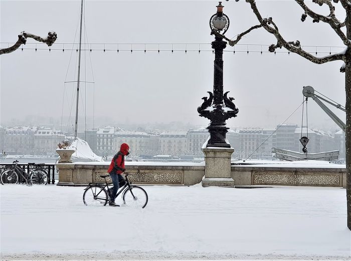 Man riding bicycle on street during winter