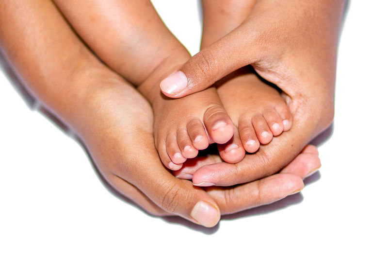 Close-up of woman hand with baby feet