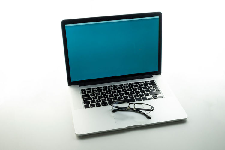 Low angle view of laptop on table against white background