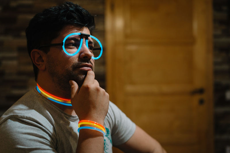 Portrait of young man wearing neon sunglasses