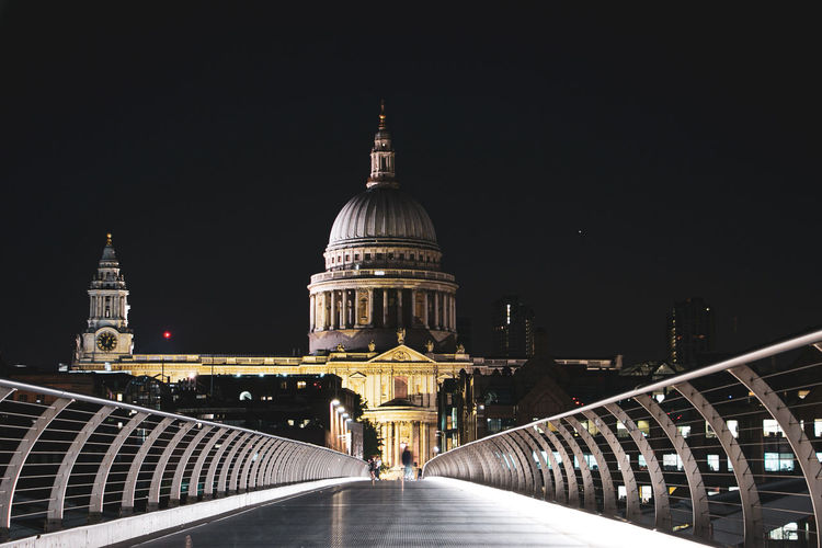 London millennium footbridge leading towards st pauls cathedral in city at night