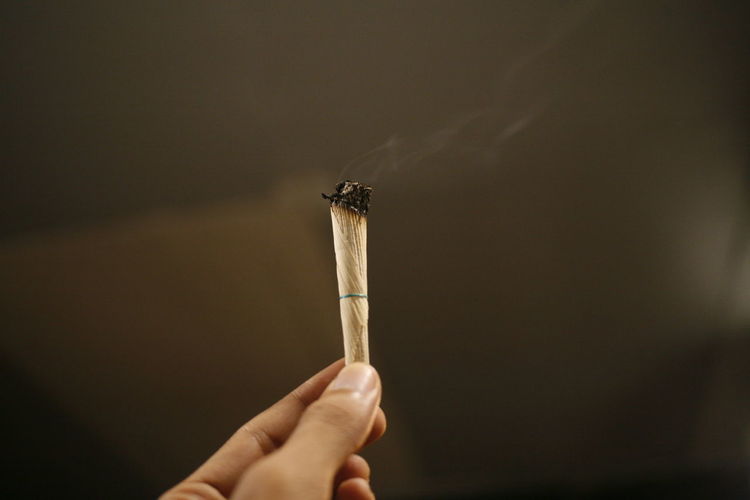 Close-up of hand holding marijuana joint