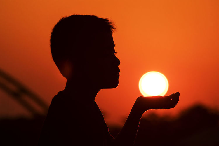 Portrait of silhouette boy against sky during sunset
