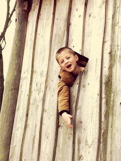 Portrait of cute boy smiling on wood