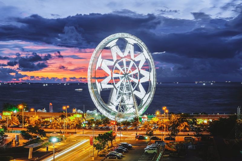 Illuminated ferris wheel in city at night
