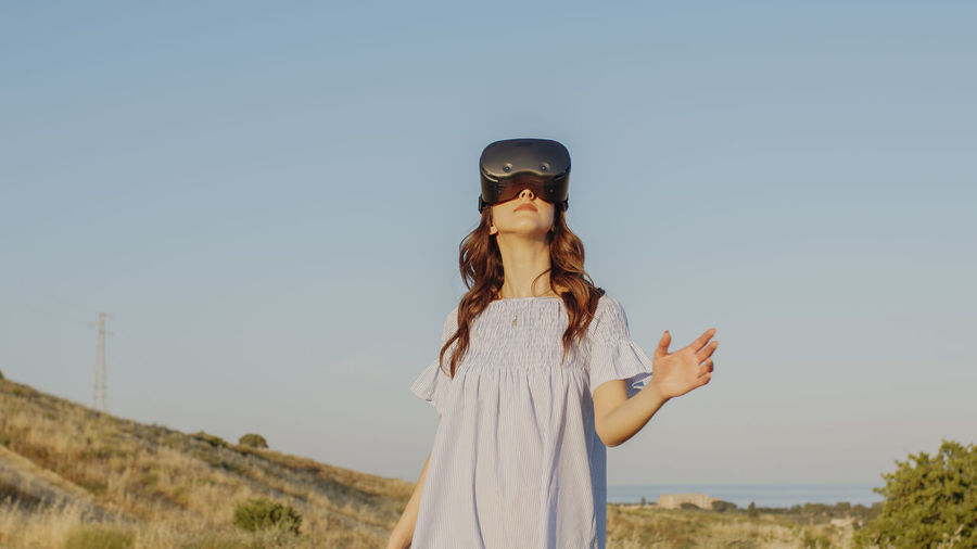 Girl with virtual reality glasses looks at the futuristic nature