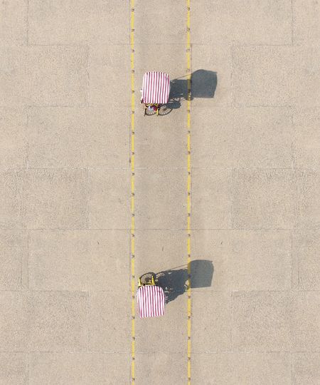 HIGH ANGLE VIEW OF MULTI COLORED UMBRELLA ON CONCRETE