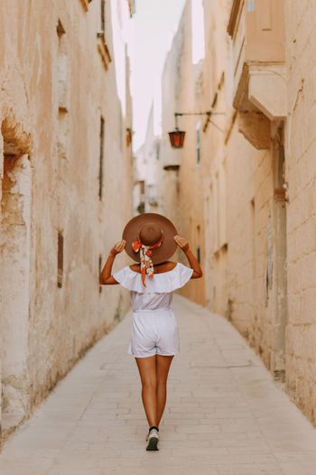 Full length of woman standing amidst buildings