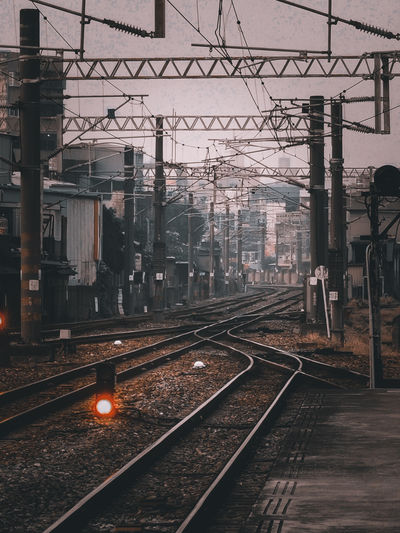 Railroad tracks in city against sky