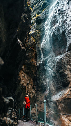 Full length of woman standing by waterfall