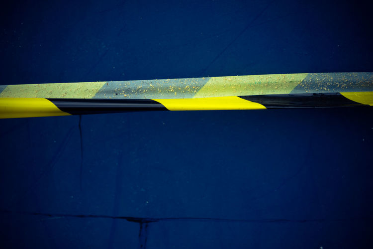 Close-up of cordon tape against blue wall