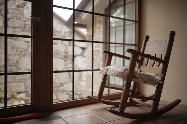 Empty rocking chair next to the window at home