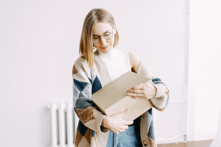 A girl receives a parcel from a courier, delivery, order, box, online shopping, millennial, hipster, 