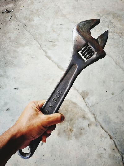 High angle view of person hand holding spanner