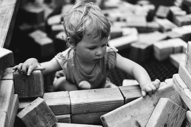 Portrait of baby girl playing in wooden house