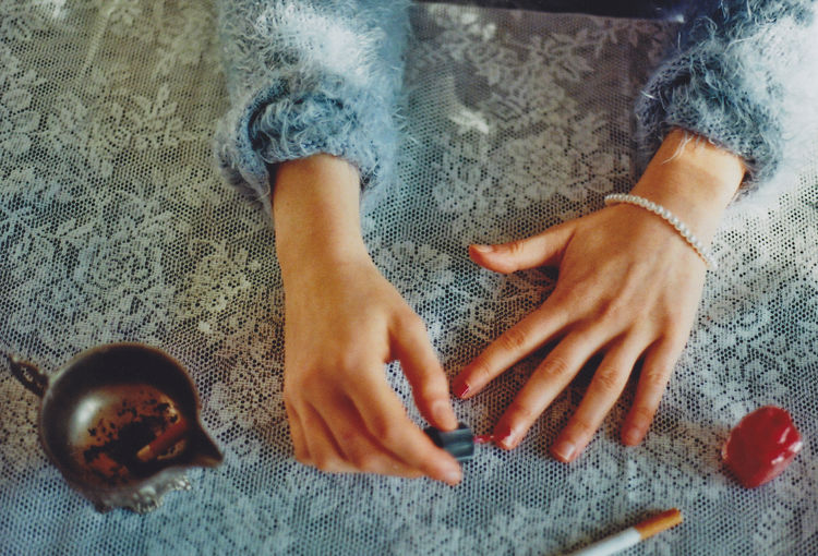 Cropped hands of woman applying nail polish