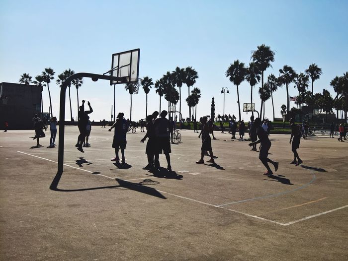 People playing basketball against sky