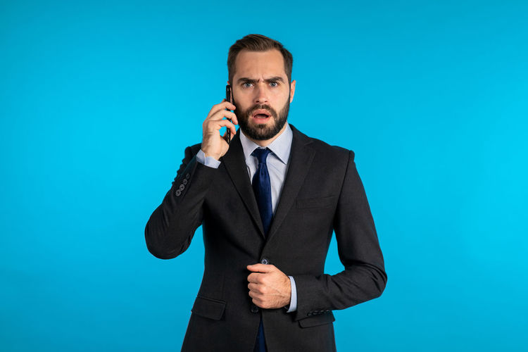 Mid adult man standing against blue background