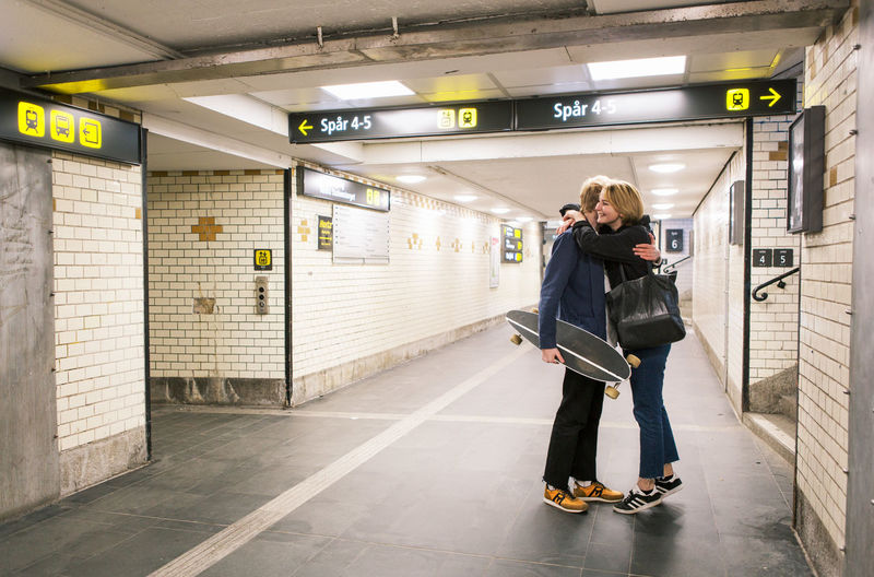 Full length of young couple embracing in underground walkway