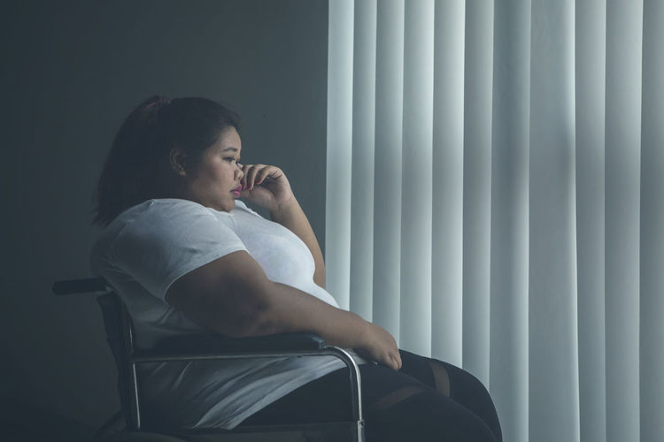 Oversized young woman sitting at home