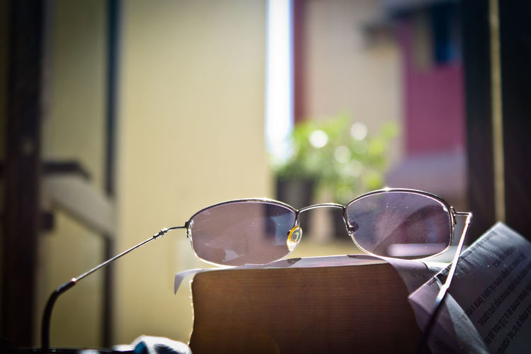 Glasses on books next to window